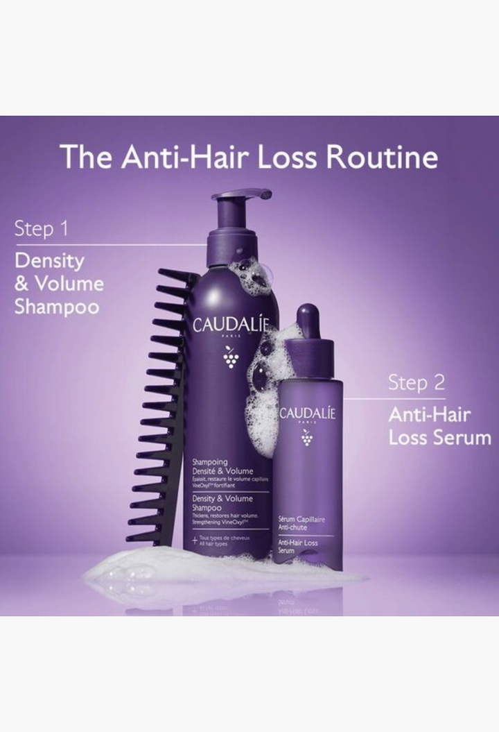 GLAM MODA Caudalie anti-hair loss shampoo and serum set in purple bottles with foam and a black hair comb